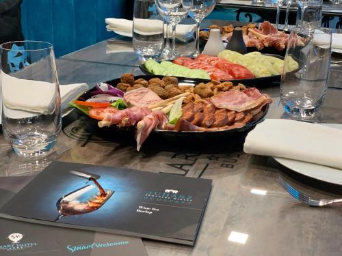 a table with a plate of food on a table at Smart Hotel Budapest in Budapest