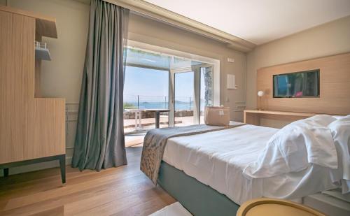 a bedroom with a bed and a view of the ocean at Golfo dei Poeti Relais & Spa in Ameglia