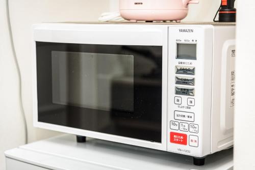 a microwave oven sitting on top of a shelf at Cocostay The Peace Memorial Park ココステイ平和記念公園 Excellent location overlooking Peace Park! in Hiroshima