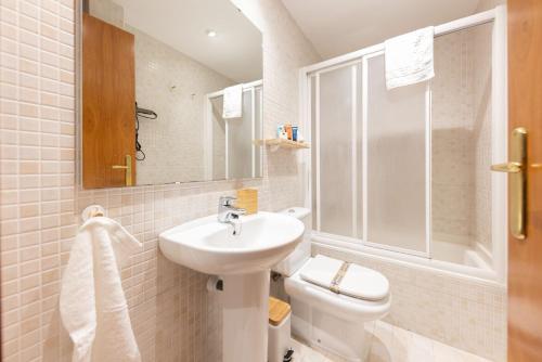 La salle de bains blanche est pourvue d'un lavabo et de toilettes. dans l'établissement Bravissimo Sant Martí, à Gérone