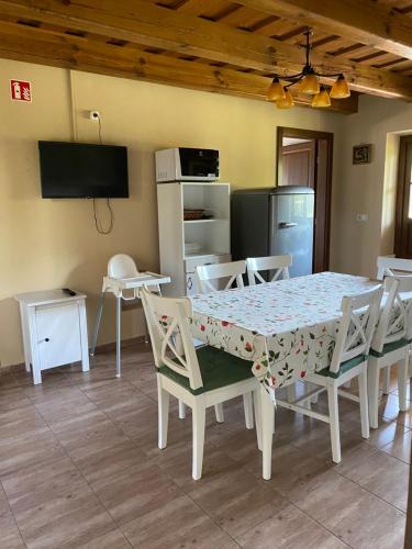 a dining room with a table and chairs and a television at Csodaszarvas Vendégházak in Rábahidvég