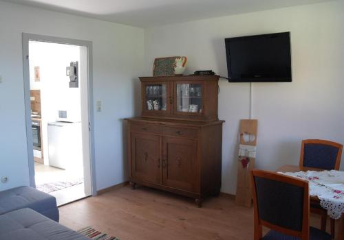 a living room with a tv and a wooden cabinet at Ferienhaus Bayerwald in Ringelai