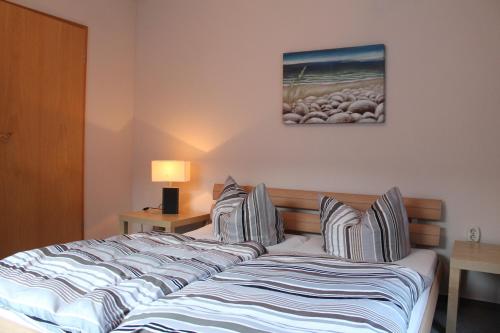 1 dormitorio con 1 cama con almohadas a rayas en Ferienwohnungen Rügen, en Ostseebad Sellin