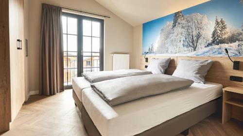 ein Schlafzimmer mit einem großen Bett mit einem Gemälde an der Wand in der Unterkunft UplandParcs Winterberg in Winterberg