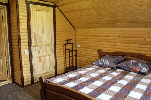 a bedroom with a bed in a log cabin at Відпочинковий комплекс "Alpha Plus" in Yablunytsya