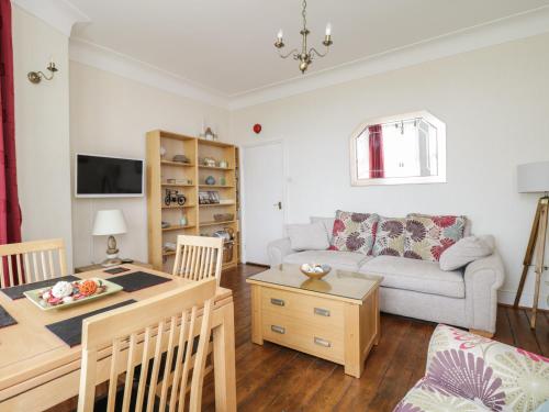 a living room with a couch and a table at The Nook in Tywyn