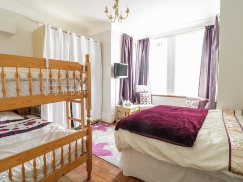 a bedroom with a bed and a large window at The Nook in Tywyn