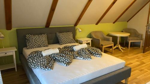 a bed with black and white pillows in a room at Csodaszarvas Vendégházak in Rábahidvég
