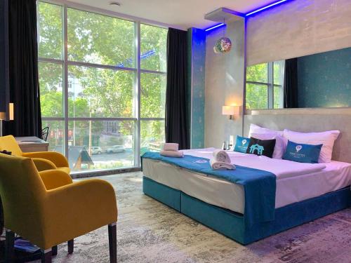 Smart Hotel Budapest & Apartments في بودابست: غرفة نوم بسرير كبير وكرسي اصفر