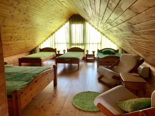 ein Zimmer mit vielen Betten und Stühlen in einem Gebäude in der Unterkunft Brīvdienu mājas Pārupes in Bauska