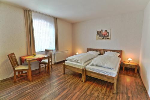 a bedroom with two beds and a table and chairs at Hotel Restaurant Schute in Emstek