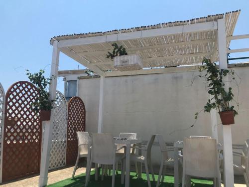 a table and chairs on a patio with a pergola at B&B Vistamareblu in San Foca