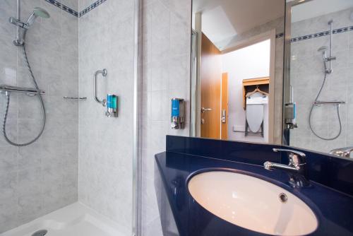 uma casa de banho com um lavatório e um chuveiro em Holiday Inn Express Stafford, an IHG Hotel em Stafford