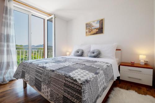 a bedroom with a bed and a large window at Villa Rustica in Neum