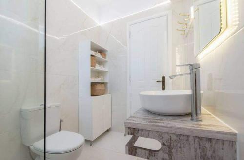 a white bathroom with a sink and a toilet at Alta Vista Luxury House in Kardamaina