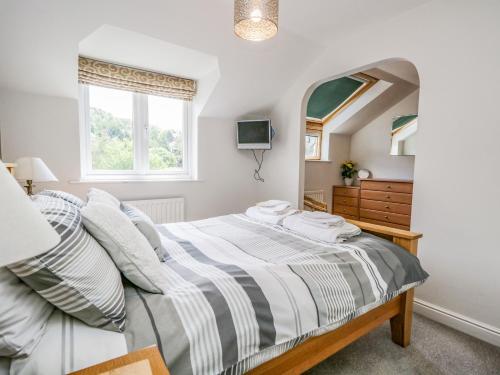 um quarto com uma cama e um espelho em Grimbles Cottage em Ulverston