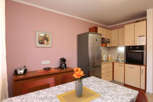 una cucina con un vaso di fiori su un tavolo di Apartment Boltar a Šilo