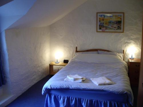 a bedroom with a bed with two towels on it at Poet's Cottage in Trefriw