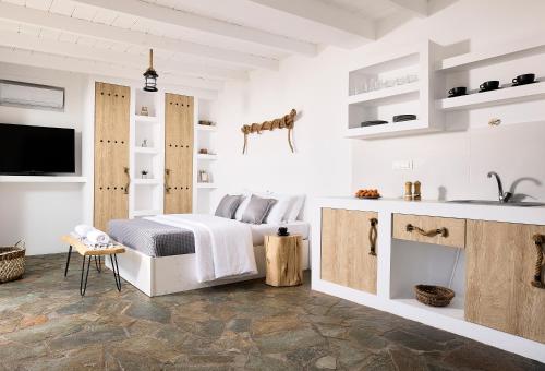 Habitación blanca con cama y lavabo en Cinco Suites, en Kithnos