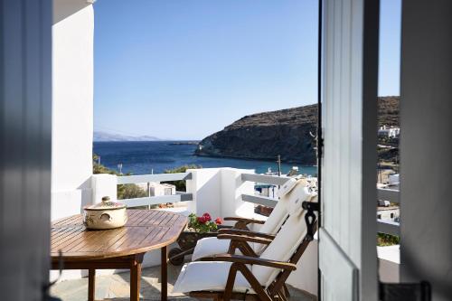 a table and chairs on a balcony with a view of the ocean at Cinco Suites in Kithnos