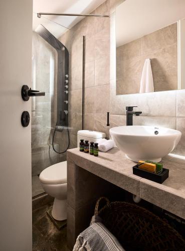 a bathroom with a sink and a toilet at Cinco Suites in Kithnos