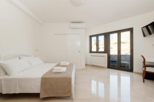 biała sypialnia z łóżkiem i stołem w obiekcie B&B Castello Otranto w mieście Otranto