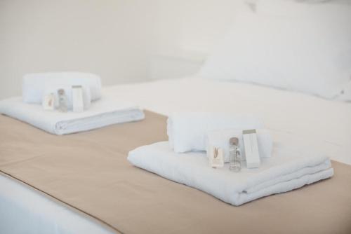 dwa białe ręczniki siedzące na łóżku w obiekcie B&B Castello Otranto w mieście Otranto