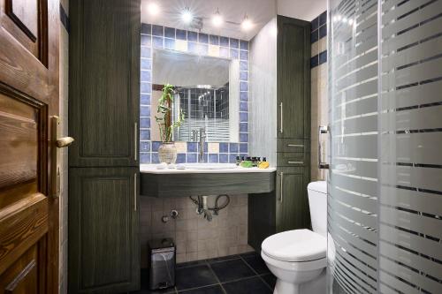 a bathroom with a toilet and a sink at Cinco Suites in Kithnos