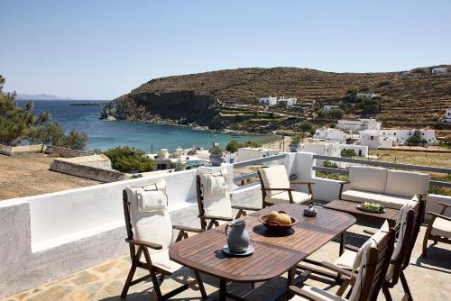 a table and chairs on a balcony with a view of the ocean at Cinco Suites in Kithnos