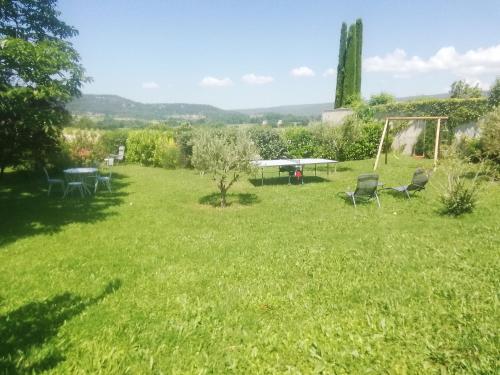 a garden with chairs and a table in the grass at Les Granges in Villars
