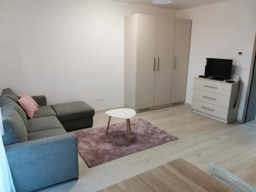 uma sala de estar com um sofá e uma mesa em Éva Apartmanház em Csopak