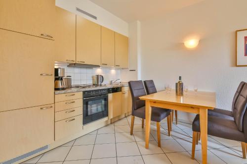 Una cocina con una mesa de madera y una mesa y sillas. en Apartment Diana mit Terrasse, en Zempin