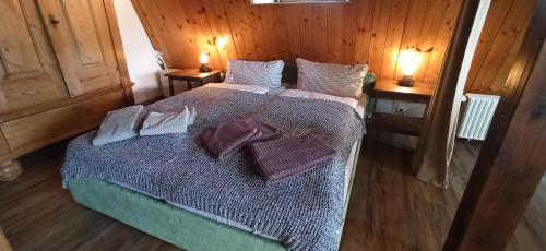 a bedroom with a bed with pillows and two lamps at Kapitän Hansen Haus- Obergeschoss in Oldsum