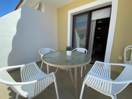 a glass table and chairs on a balcony at Kyklades Resort & Spa in Paralimni