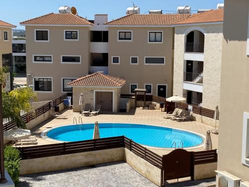 a swimming pool in front of a building at Kyklades Resort & Spa in Paralimni
