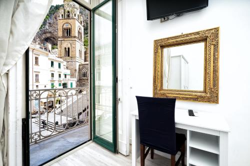 a room with a window with a view of the city at Hotel Fontana in Amalfi