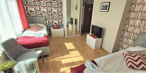 a room with a bed and a couch and a television at Villa Magna in Gdynia
