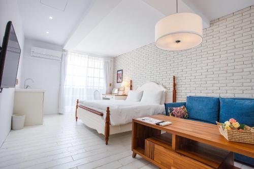 Un dormitorio con una cama, un sofá y una mesa. en 4 Design Inn, en Tainan