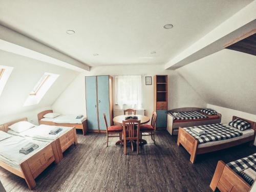 Habitación con 2 camas, mesa y sillas en Apartment and rooms Maraton en Kranjska Gora