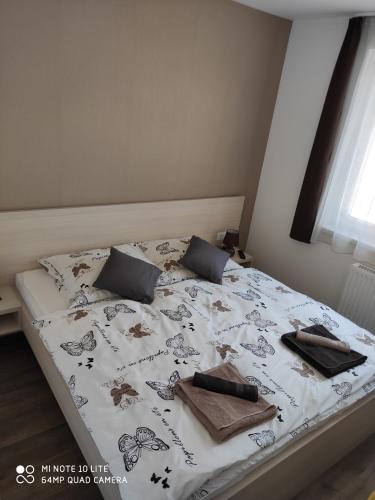 ein Bett in einem Schlafzimmer mit einer Tagesdecke mit Tieren drauf in der Unterkunft Sweet Home Apartments in Sárvár