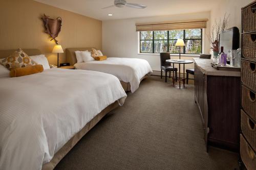a hotel room with two beds and a table at PlumpJack Inn in Olympic Valley