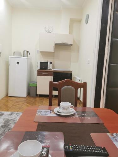 a small kitchen with a table with a remote control at Baross-hat 5 in Szolnok