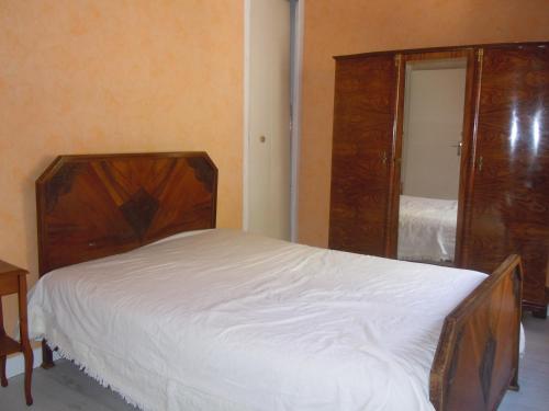 - une chambre avec un lit en bois et un miroir dans l'établissement MAISON AUGUY, à Saint-Julien-Boutières