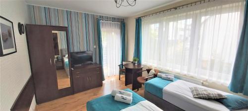 a hotel room with two beds and a mirror at Villa Magna in Gdynia