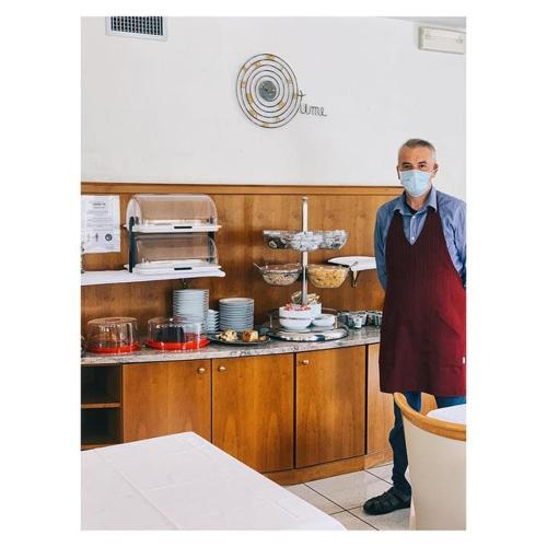 a man standing in a kitchen wearing a mask at Garni Enrosadira in Vigo di Fassa