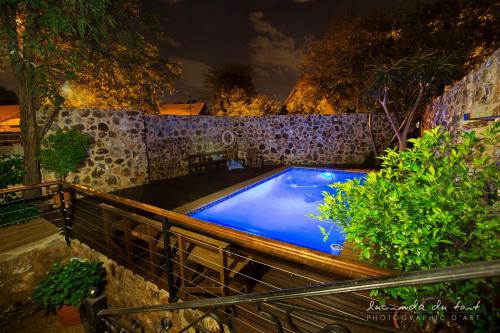 a swimming pool in a backyard at night at Kleinkaap Boutique Hotel in Centurion