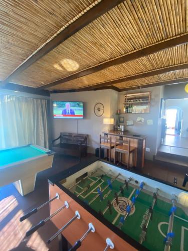 a living room with a pool table and a tv at Dolphin Circle Bed and Breakfast in Plettenberg Bay