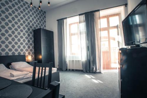 a bedroom with a bed and a tv and a window at NeoApartments - Rynek Pod Gryfami in Wrocław
