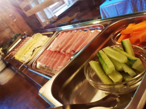 a buffet line with hot dogs and vegetables on at Pension Almhof Baumgarten in Bad Reichenhall