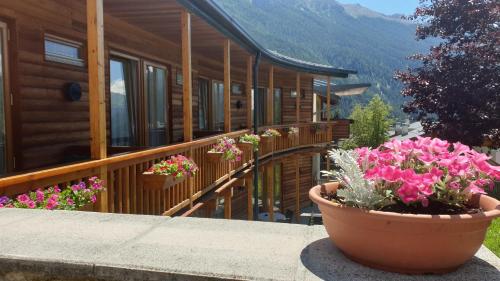 a house with flowers in a pot on a balcony at Garni Enrosadira in Vigo di Fassa